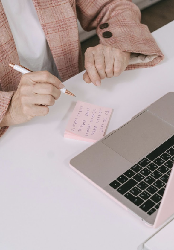 Busy realtor mom planning how to get real estate clients with a to-do list and laptop.